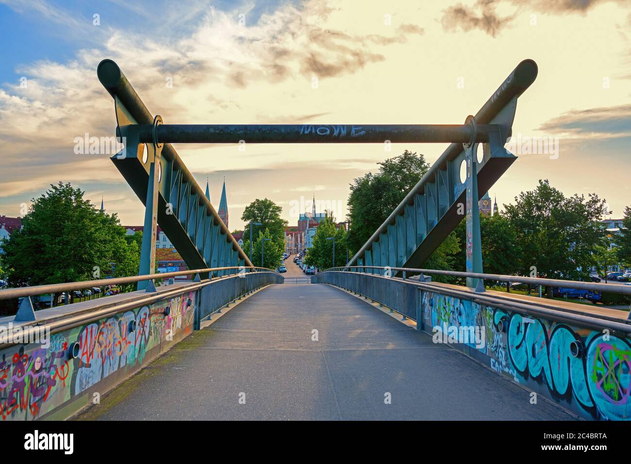 Lubecca, Germania, 24 giugno 2020: Ponte pedonale con graffiti attraverso il canale al centro della storica città anseatica di Lubecca , nuvoloso s Foto Stock