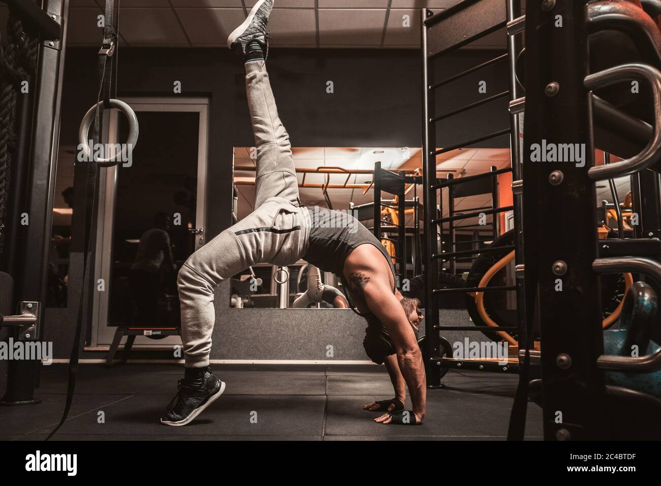 Un uomo sportivo in palestra sta facendo esercizi di yoga. Sirsasana o Kapalasana, la posizione sulla testa. Benefici mentali dello yoga. Foto Stock