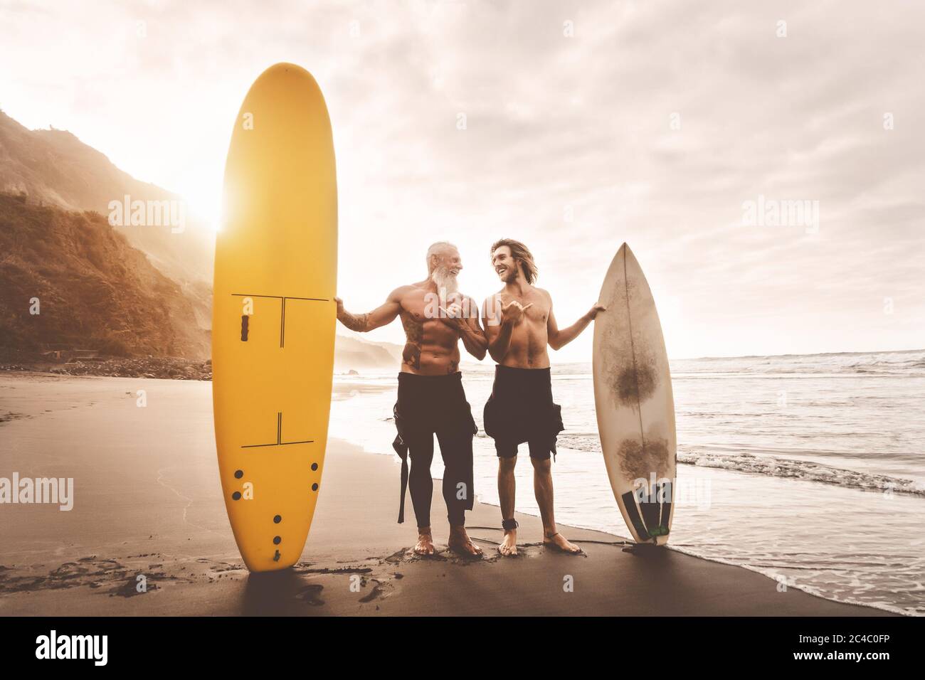 Amici felici che navigano insieme sull'oceano tropicale - gente sportiva che si diverte durante la giornata di surf di vacanza Foto Stock