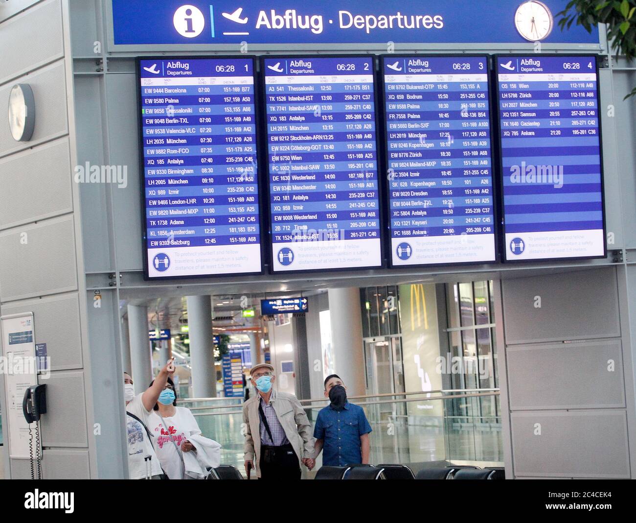 Duesseldorf, Germania. 26 Giugno 2020. I passeggeri che indossano maschere guardano le bacheche informative dell'aeroporto di Düsseldorf con gli orari di partenza. In Nord Reno-Westfalia le vacanze scolastiche iniziano il Venerdì credito: Roland Weihrauch/dpa/Alamy Live News Foto Stock