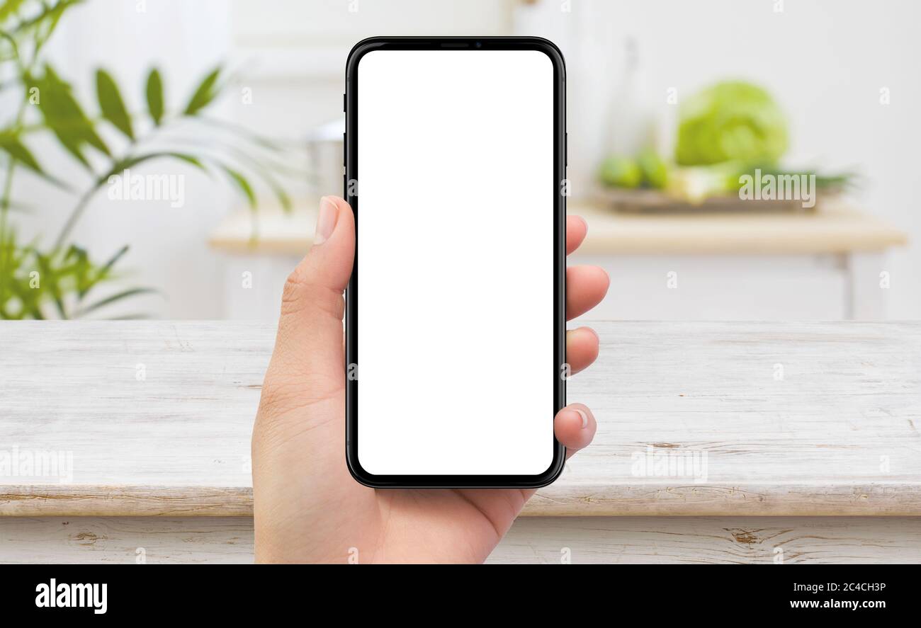 Isolato uomo sinistra mano che tiene nero cellulare smartphone mockup dispositivo in cucina Foto Stock