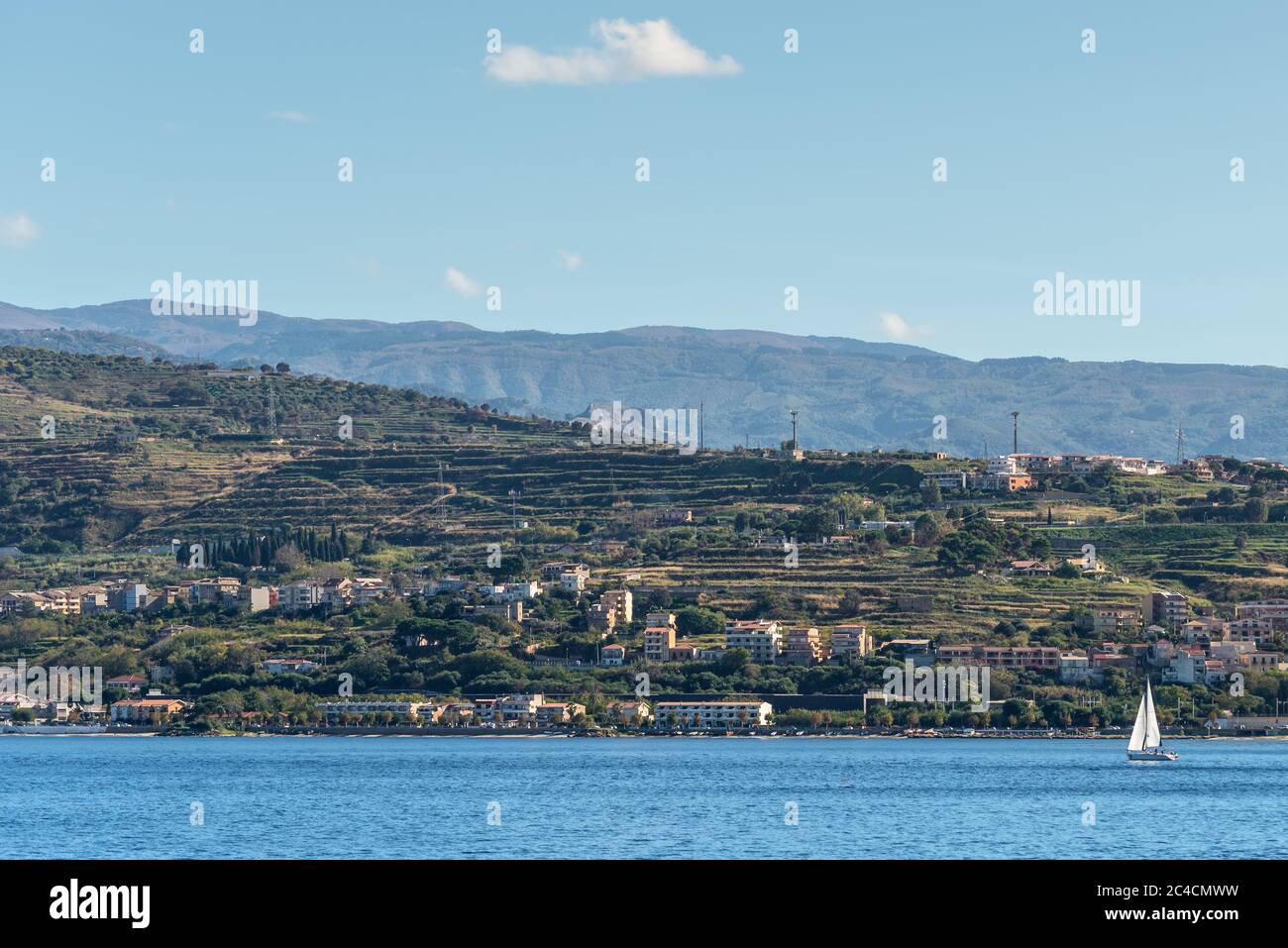 Lo stretto di Messina collegai il Mar Mediterraneo e il Tirreno e l'isola Sicilia con cielo blu e costa come sfondo, vista dal lungomare banchina wa Foto Stock