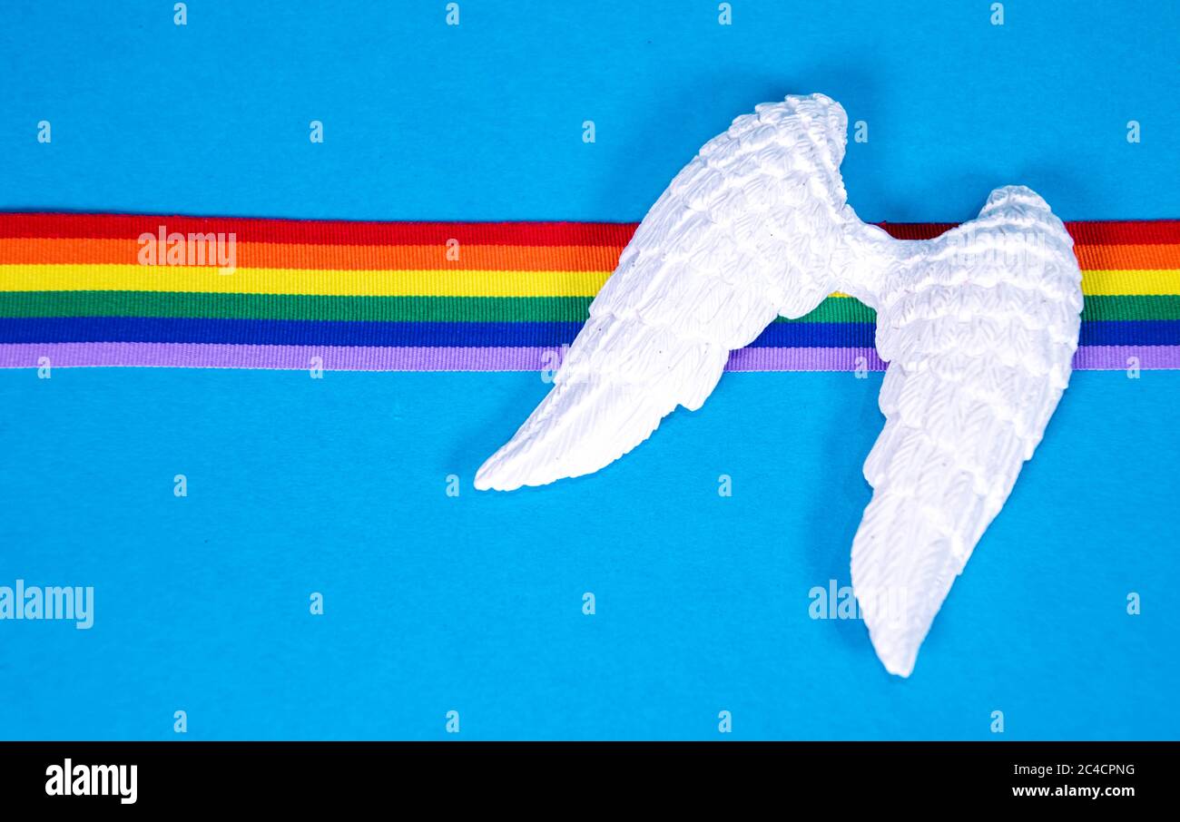 Un set di ali d'angelo bianche con nastro arcobaleno colorato, per ricordare coloro che sono morti. Foto Stock