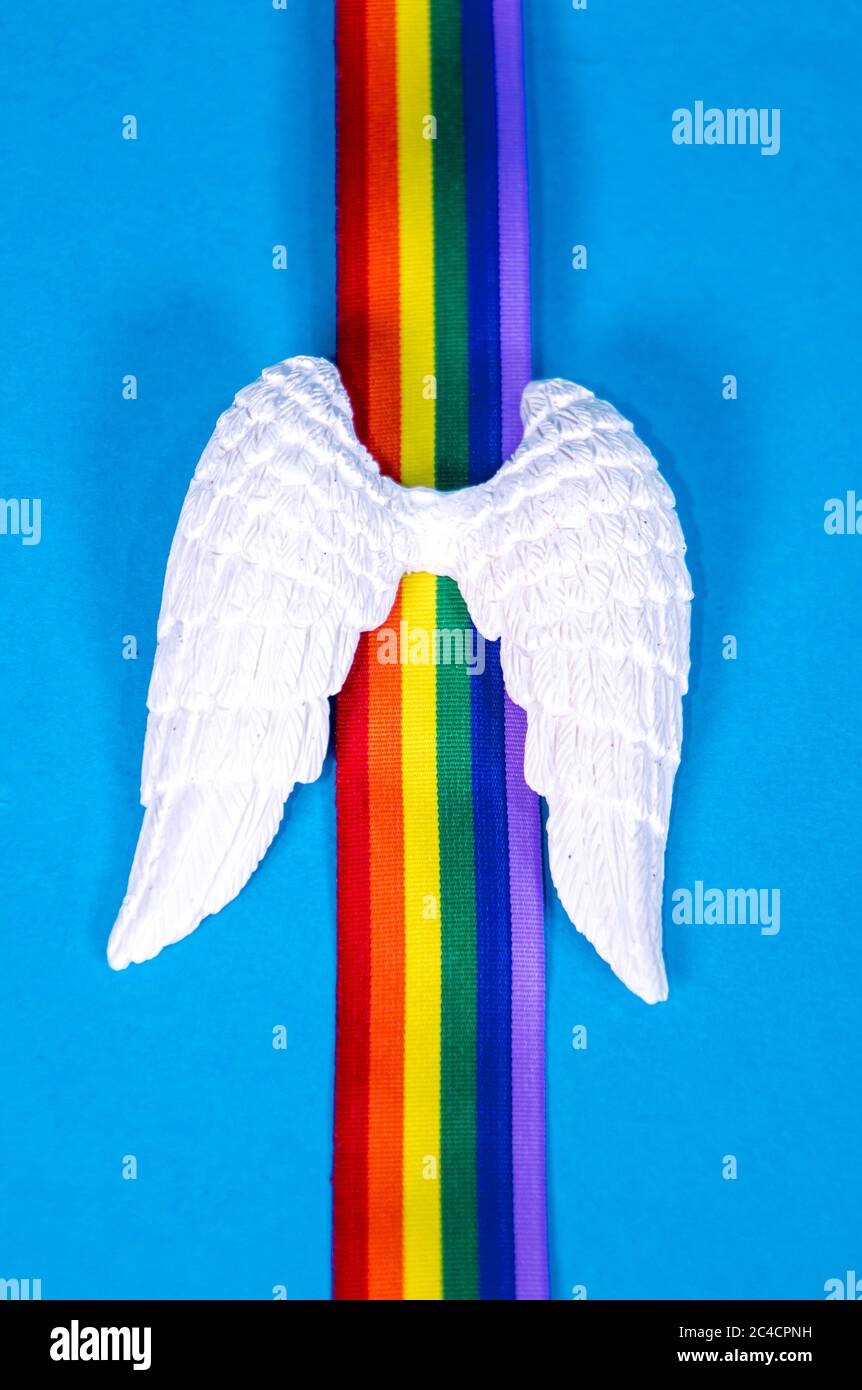 Un set di ali d'angelo bianche con nastro arcobaleno colorato, per ricordare coloro che sono morti. Foto Stock
