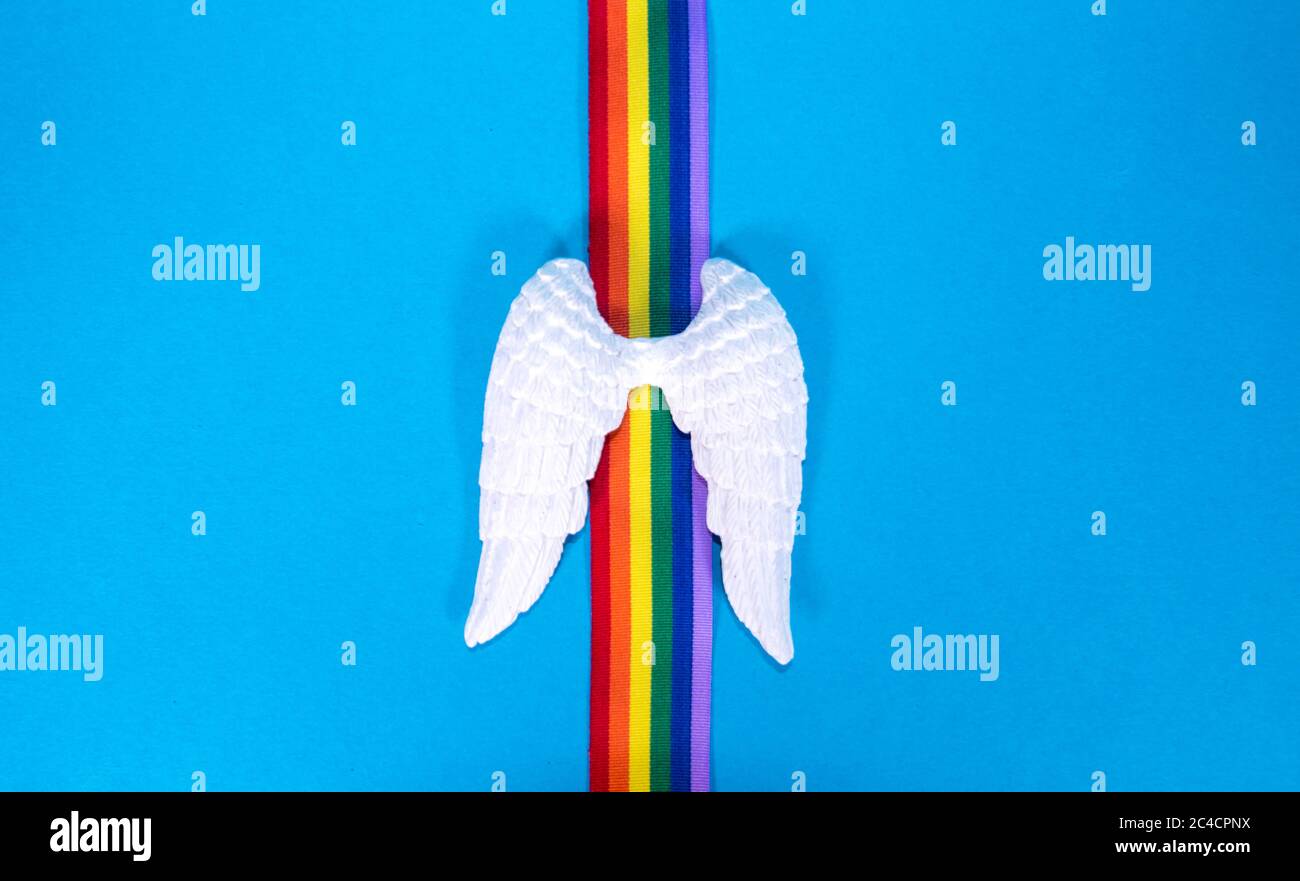 Un set di ali d'angelo bianche con nastro arcobaleno colorato, per ricordare coloro che sono morti. Foto Stock