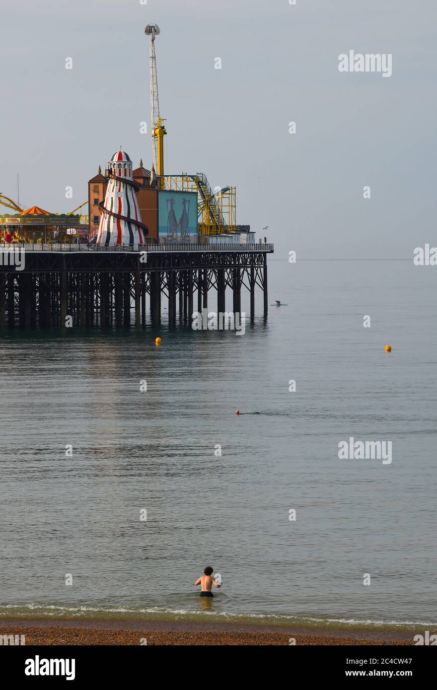 Brighton UK 26 giugno 2020 - UN nuotatore entra nel mare di Brighton questa mattina in un'altra bella giornata di sole caldo . Le folle si sono affollate ieri a Brighton, che è stato il giorno più caldo dell'anno finora: Credit Simon Dack / Alamy Live News Foto Stock