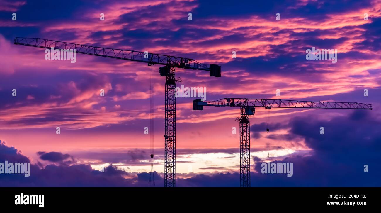 Banner cantiere con gru su tramonto viola Foto Stock