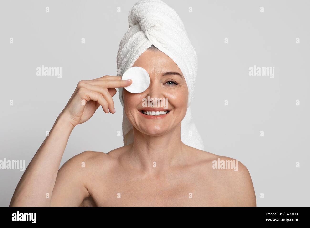 Routine di cura della pelle. Positivo coprente occhi donna matura con imbottitura in cotone Foto Stock