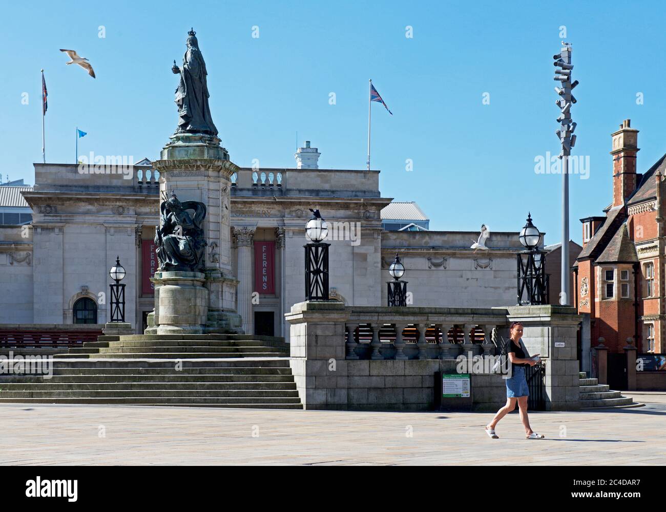 Donna che attraversa Queen Victoria Square, Hull, Humberside, East Yorkshire, Inghilterra UK Foto Stock