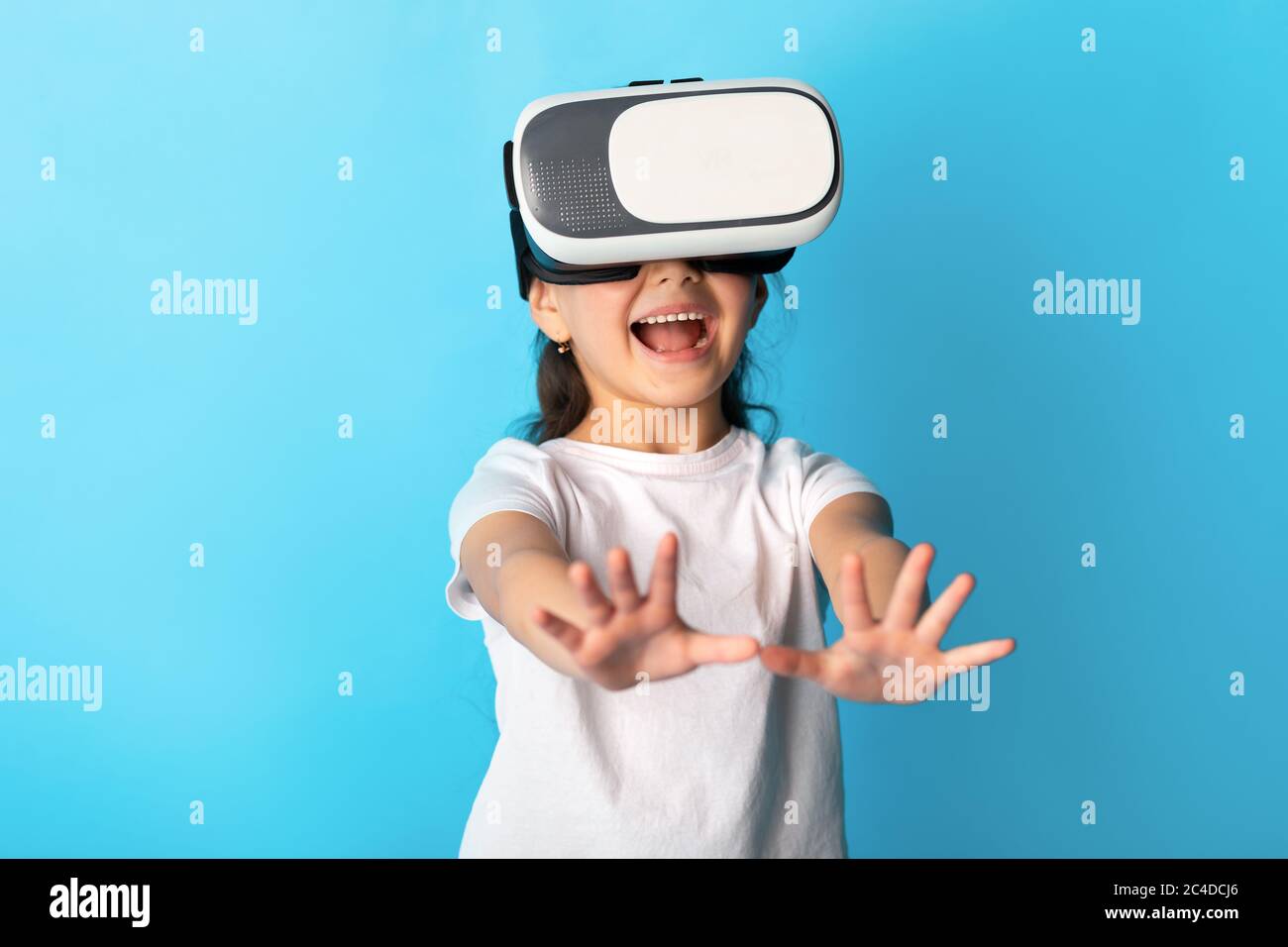 Bambina che indossa occhiali di protezione per la realtà virtuale in studio Foto Stock