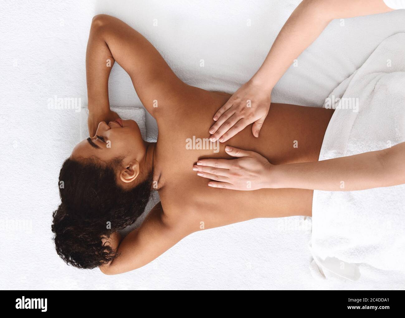 Massaggio tranquillo africano ragazza tornare indietro, sfondo bianco Foto Stock