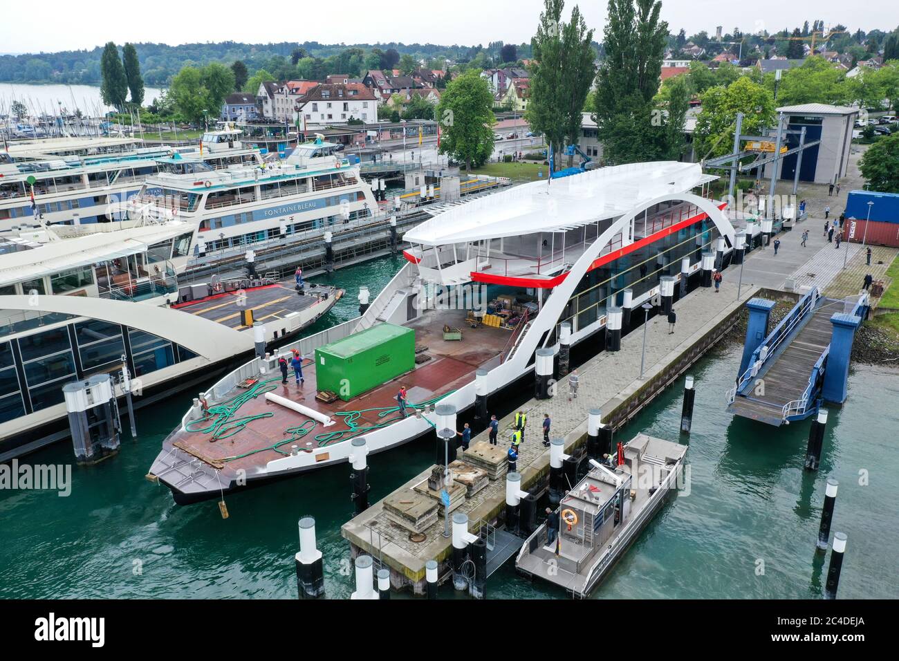 Konstanz, Germania. 26 Giugno 2020. Il guscio di un nuovo traghetto viene attratto nel porto dei traghetti dopo che è stato spinto attraverso il lago di Costanza da un altro traghetto (sparato con il drone). Per la prima volta, il traghetto ha un nuovo strato di vernice. Invece di blu e bianco come i vecchi traghetti, il nuovo traghetto è ora rosso e bianco. Credit: Felix Kästle/dpa/Alamy Live News Foto Stock