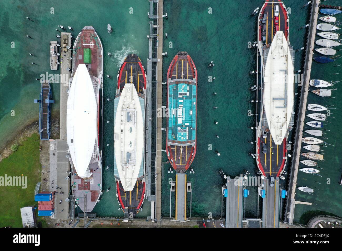Konstanz, Germania. 26 Giugno 2020. Il guscio (l) di un nuovo traghetto è legato nel porto dopo essere stato spinto attraverso il lago di Costanza da un altro traghetto (sparato con il drone). Per la prima volta, il traghetto ha un nuovo strato di vernice. Invece di blu e bianco come i vecchi traghetti, il nuovo traghetto è ora rosso-bianco. Credit: Felix Kästle/dpa/Alamy Live News Foto Stock