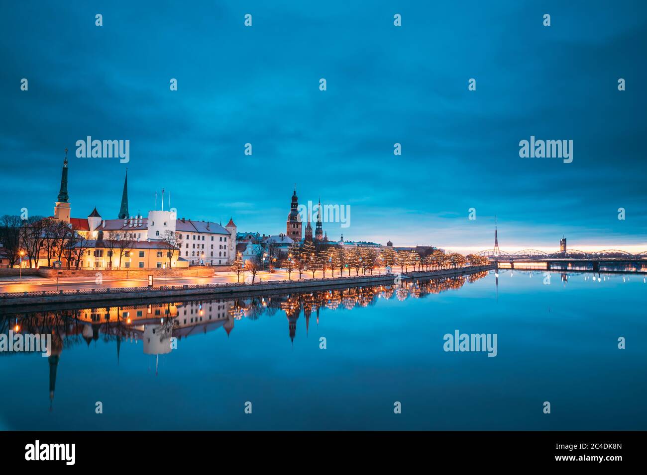 Riga, Lettonia, Europa. Paesaggio urbano al mattino. Vista notturna del Castello, della Cattedrale a cupola e della Chiesa di San Pietro. Luogo popolare con famosi monumenti Foto Stock
