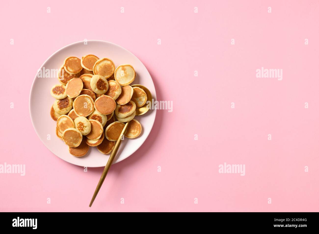 Minuscoli pancake di cereali su rosa. Vista dall'alto. Gustosa colazione alla moda. Foto Stock