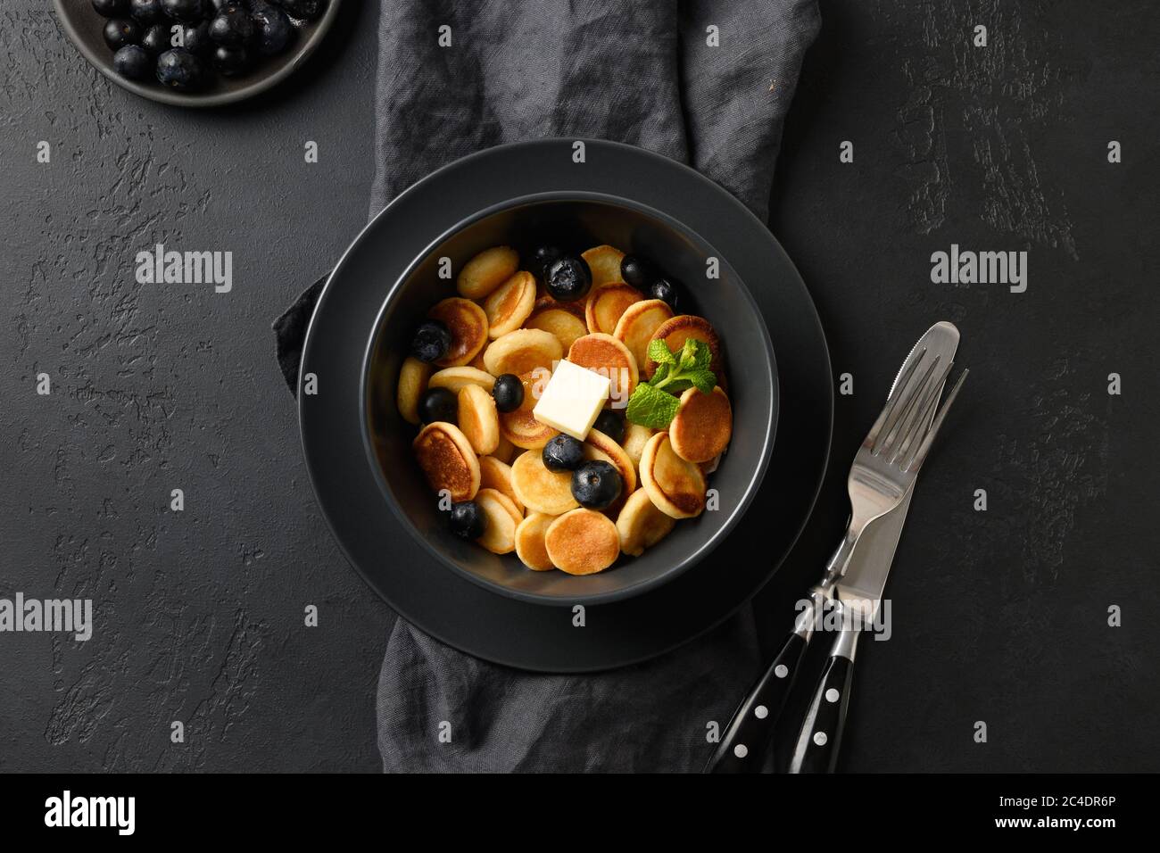 Piccola frittella fatta in casa con mirtillo su nero. Vista dall'alto. Gustosa colazione alla moda. Foto Stock