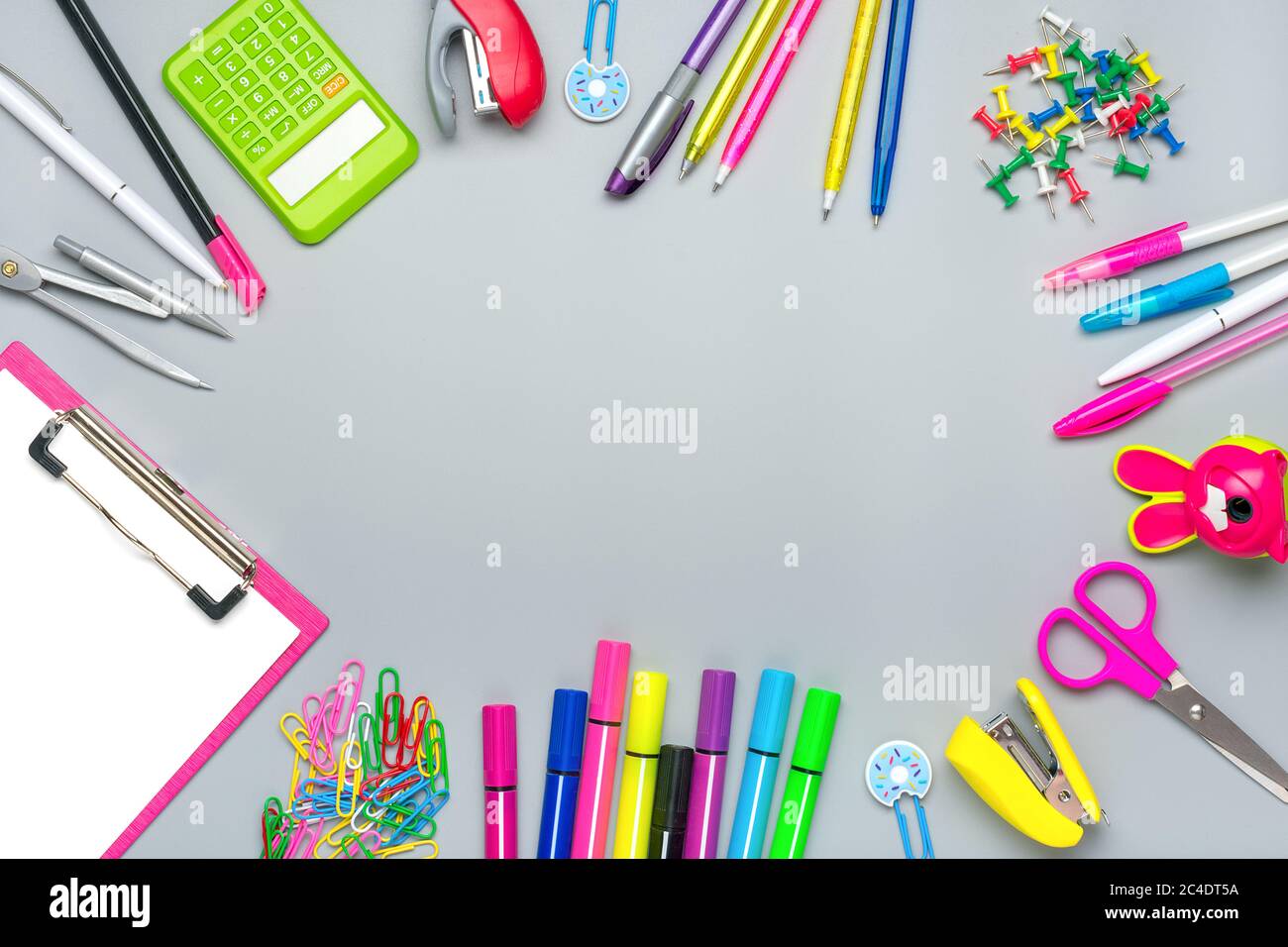 Cornice di materiale scolastico e per ufficio clip di carta, forbici, penne, pennarelli, affilatrice, calcolatrice, pinzatrice isolata su sfondo grigio Flat Lay Foto Stock