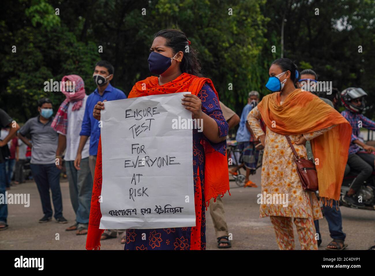 Dhaka, Bangladesh. 24 Giugno 2020. Un protettore tiene un cartello mentre indossa una maschera facciale durante la manifestazione.protesta progressiva dell'alleanza studentesca che chiede le dimissioni di Zahid Maleque, Ministro della Salute e del benessere familiare all'Università di Dhaka, in Bangladesh. Credit: SOPA Images Limited/Alamy Live News Foto Stock