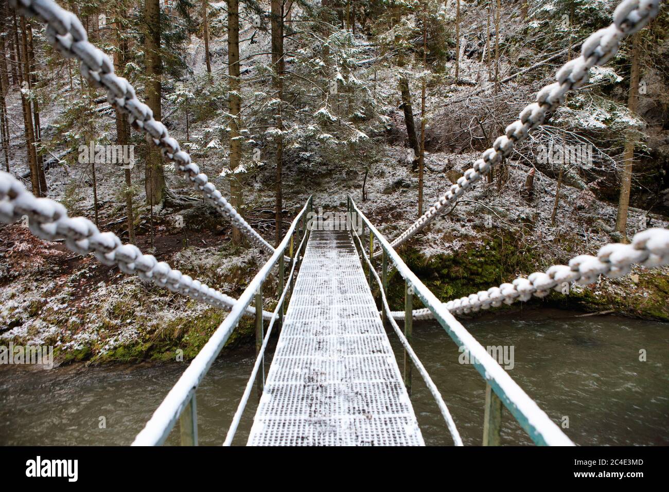 Ponte a catena innevato sul fiume Hornad nel Parco Nazionale del Paradiso Slovacco, Slovacchia Foto Stock