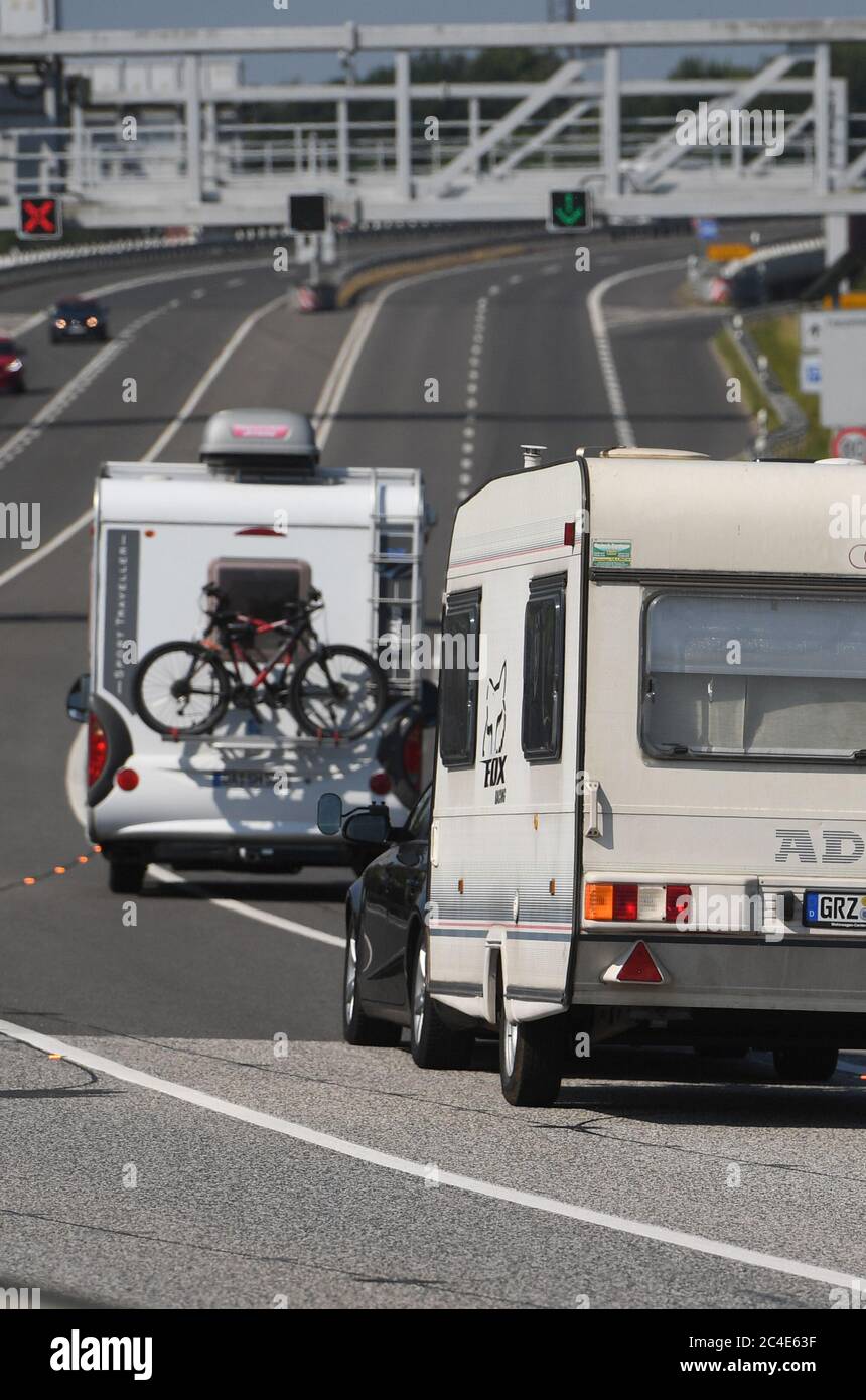 Stralsund, Germania. 26 Giugno 2020. Le case automobilistiche e le auto con rimorchi guidano sopra la Rügenbücke all'isola di Rügen. Tuttavia, i turisti non sono autorizzati a viaggiare più lontano nello stato federale. Credit: Stefan Sauer/dpa/Alamy Live News Foto Stock