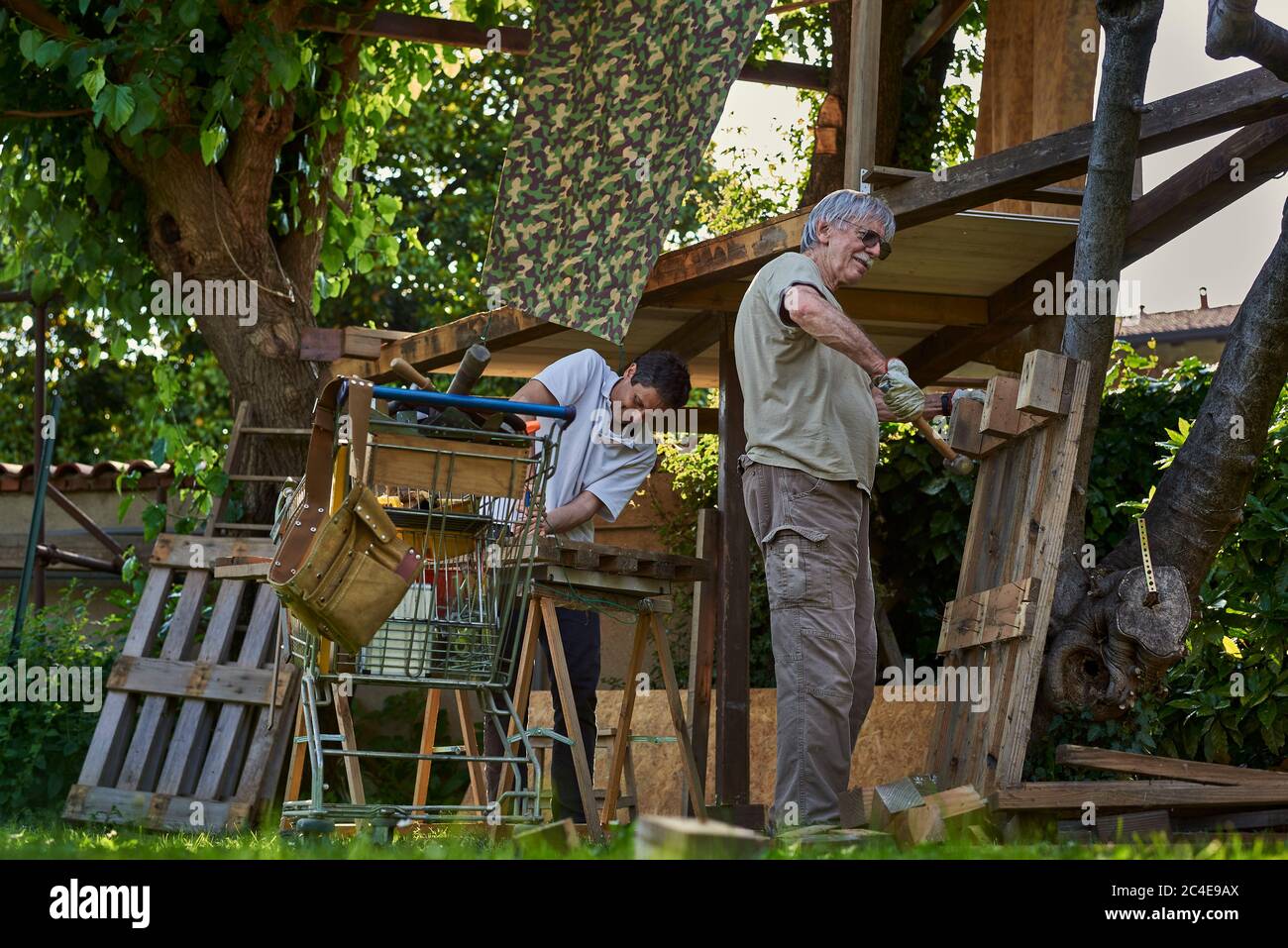 Uomini anziani attivi che lavorano sul cortile Foto Stock