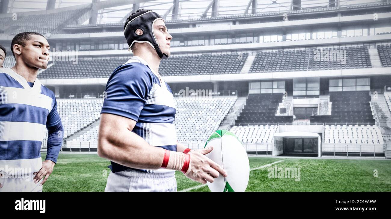 Immagine digitale composita di due giocatori di rugby che tengono la palla nello stadio sportivo Foto Stock