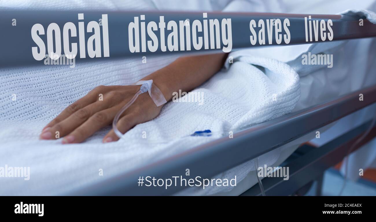 Paziente in letto di ospedale con scrittura circa la distanza sociale Foto Stock