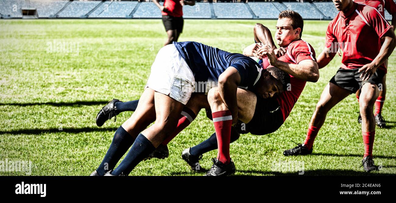 Immagine digitale composita di una squadra di giocatori di rugby che si affrontano per vincere la palla nello stadio Foto Stock