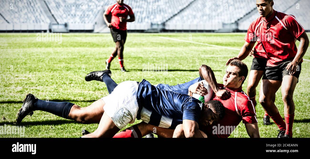 Immagine digitale composita di una squadra di giocatori di rugby che si affrontano per vincere la palla nello stadio Foto Stock
