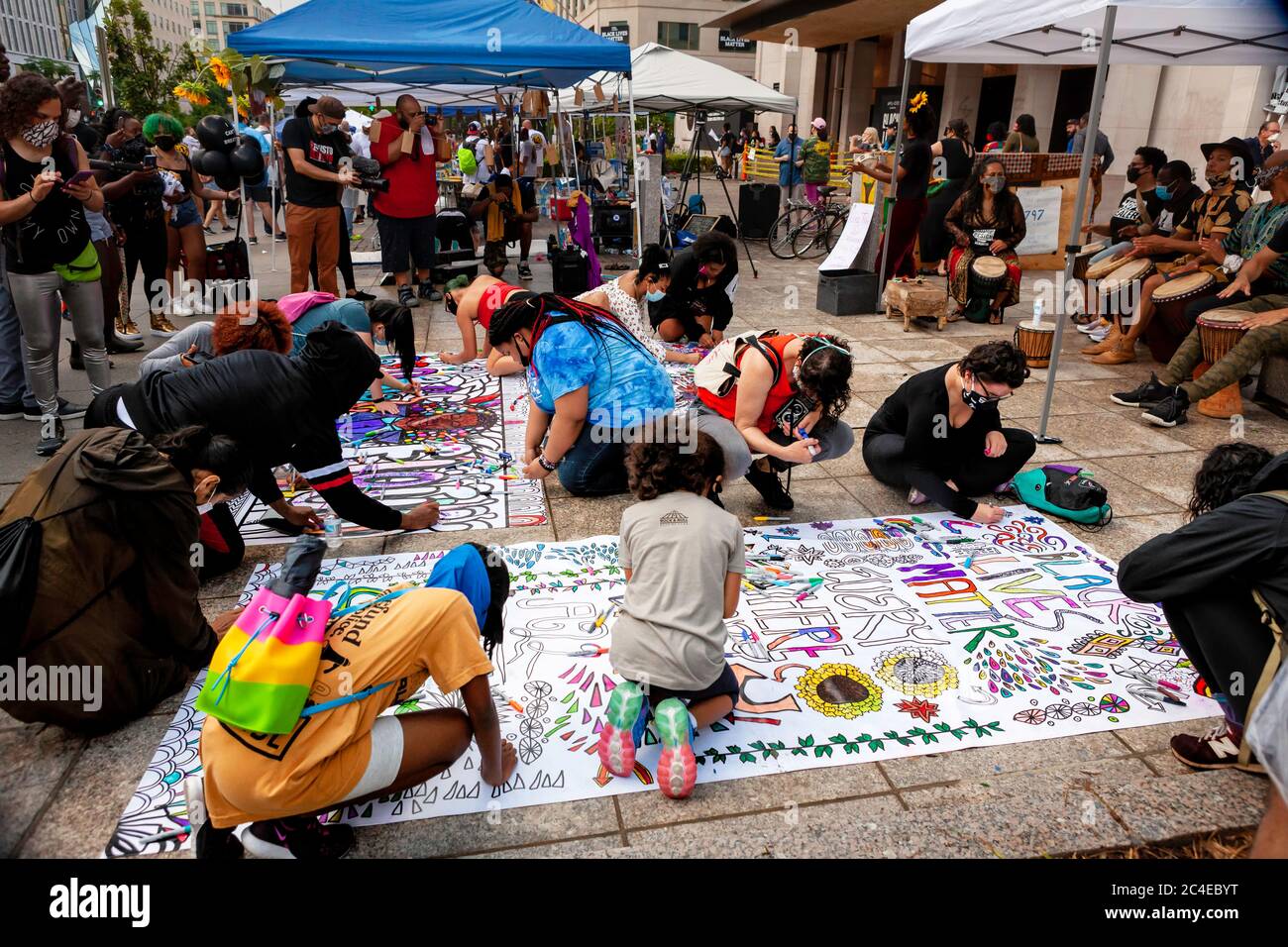 Molti giovani manifestanti lavorano in un pomeriggio piovoso sui murales da appendere a Black Lives Matter Plaza / Lafayette Square, Washington, DC, Stati Uniti Foto Stock