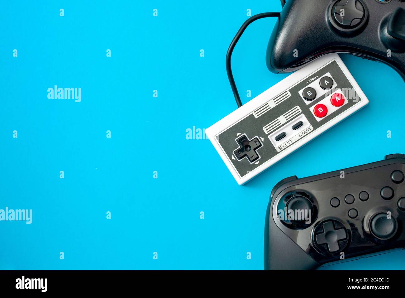 Tema di concetto di console di gioco e giochi per computer con controller di videogiochi isolati su sfondo blu con spazio di copia Foto Stock