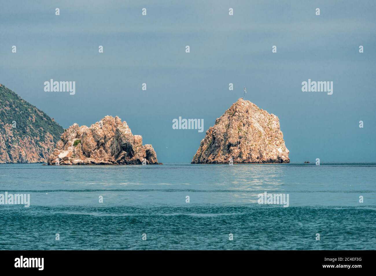 GURZUF, CRIMEA - Vista da una spiaggia in Gurzuf sulle famose rocce Adalary, due doppie-scogliere con un bordo di montagna Au-Dag in primavera mattina presto a. Foto Stock