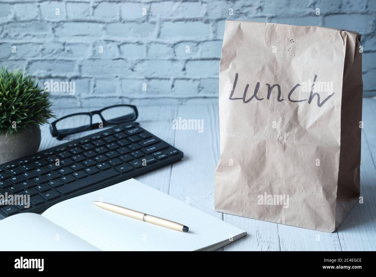 Borsa per pranzo di carta sulla scrivania dell'ufficio, per primo piano. Foto Stock