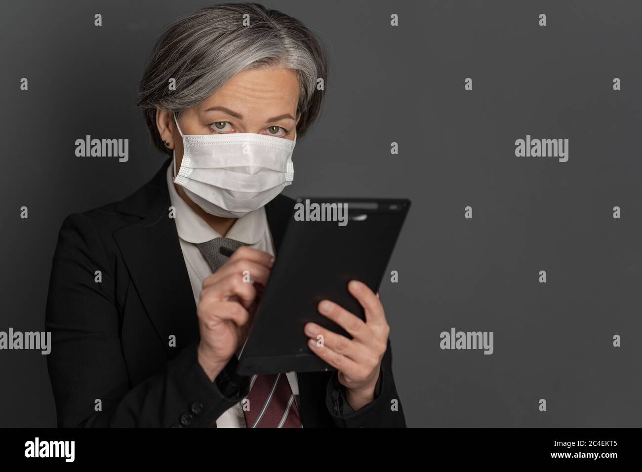 Uomo d'affari caucasico in maschera protettiva opere guardando la fotocamera. Fuoco selettivo sugli occhi femminili. Spazio vuoto per il testo sul lato destro Foto Stock