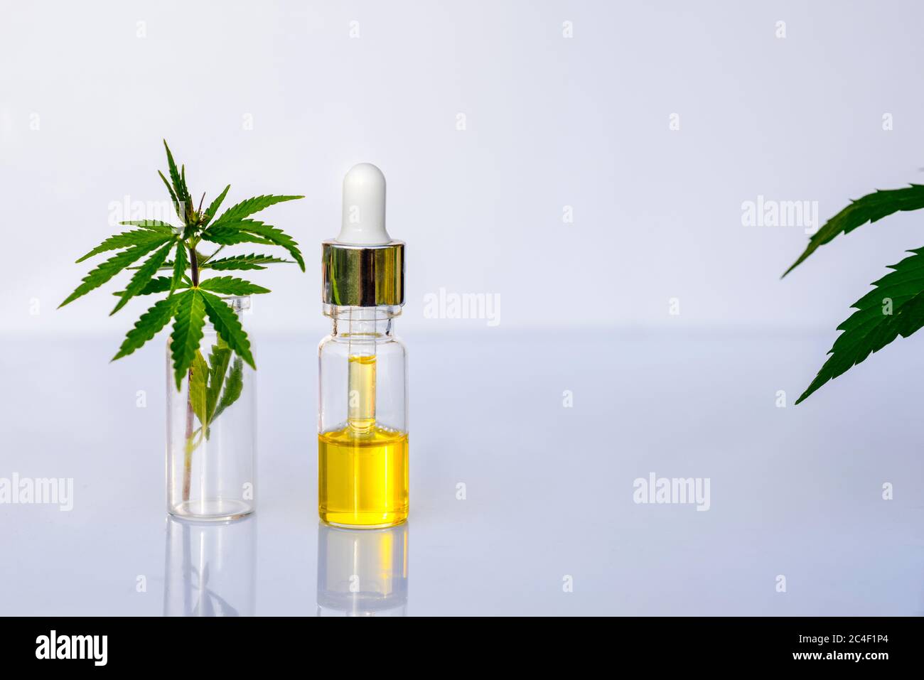 Tintura farmaceutica di olio e cannabis nel CBD su un banco di laboratorio bianco Foto Stock