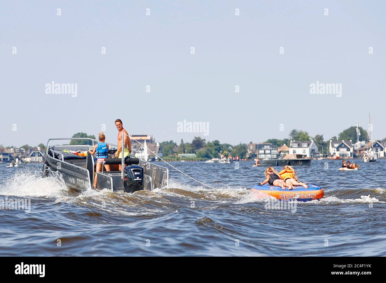 Loosdrecht, Paesi Bassi. 26 Giugno 2020. LOOSDRECHT, 26-06-2020, estate sui laghi dell'Olanda, dove le temperature hanno raggiunto i 30 gradi Celsius. Molte persone godono della loro libertà dopo un lungo periodo di blocco a causa dei coronacrisi. De Loosdrechtse plassen tijdens een warme zomerdag. Vinder achter de boot Credit: Pro Shots/Alamy Live News Foto Stock