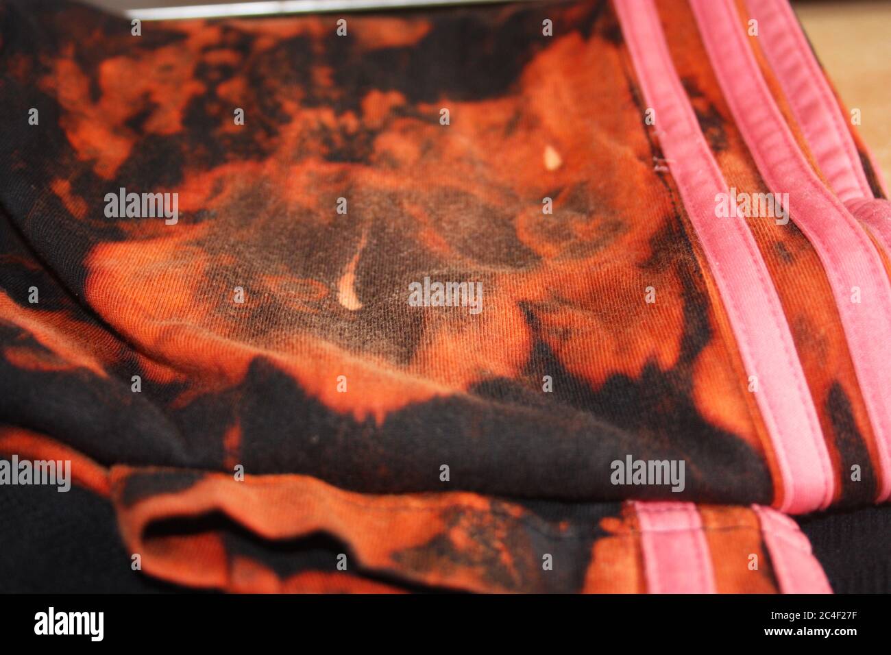 tessuto nero con candeggina e amuchina con macchie rosse e arancioni Foto  stock - Alamy