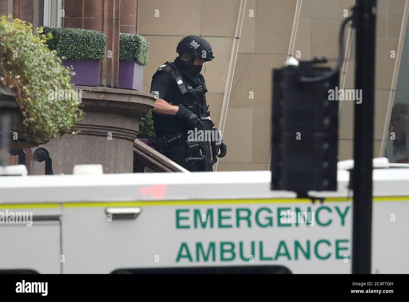 Gli ufficiali di polizia armati lasciano l'hotel Park Inn a West George Street, Glasgow, dove un uomo è stato ucciso da un ufficiale armato dopo che un altro ufficiale è stato ferito durante un attacco. Foto Stock