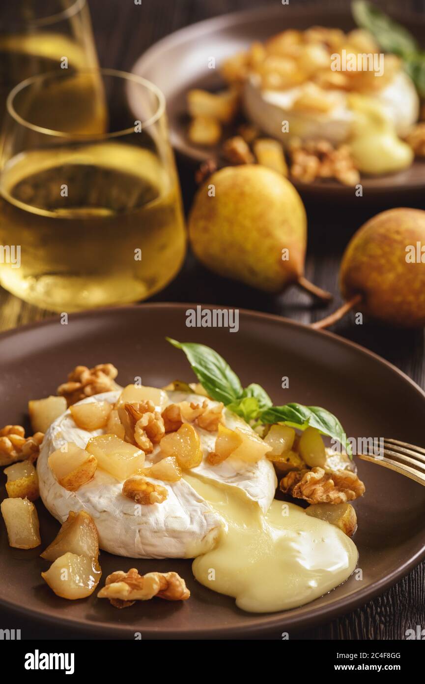 Camembert al forno con pere e noci, servito con vino bianco. Foto Stock