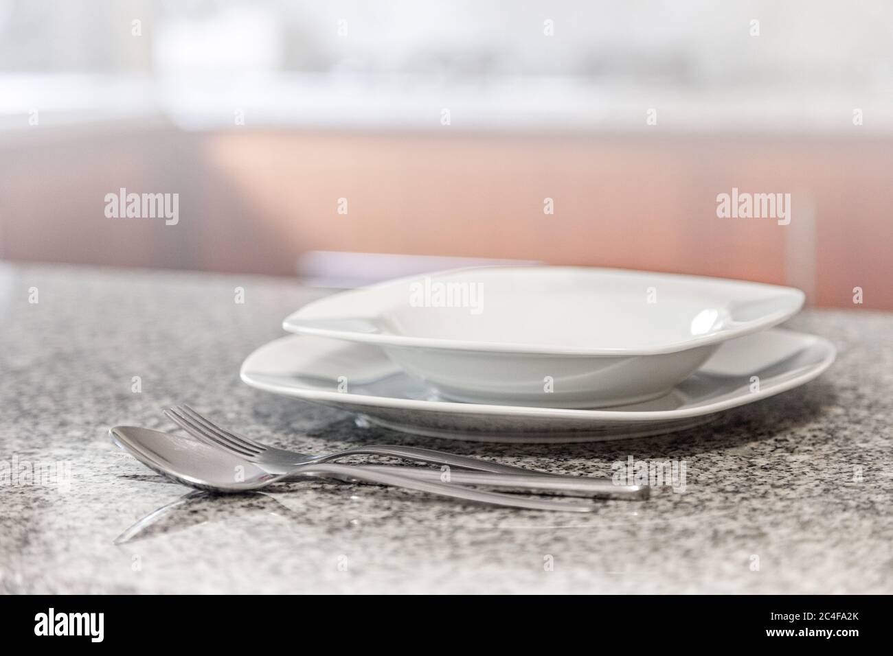 Sfocatura sfondo astratto pareti in piastrelle moderne, tavolo bianco con accessori da cucina moderni, interni di design Foto Stock