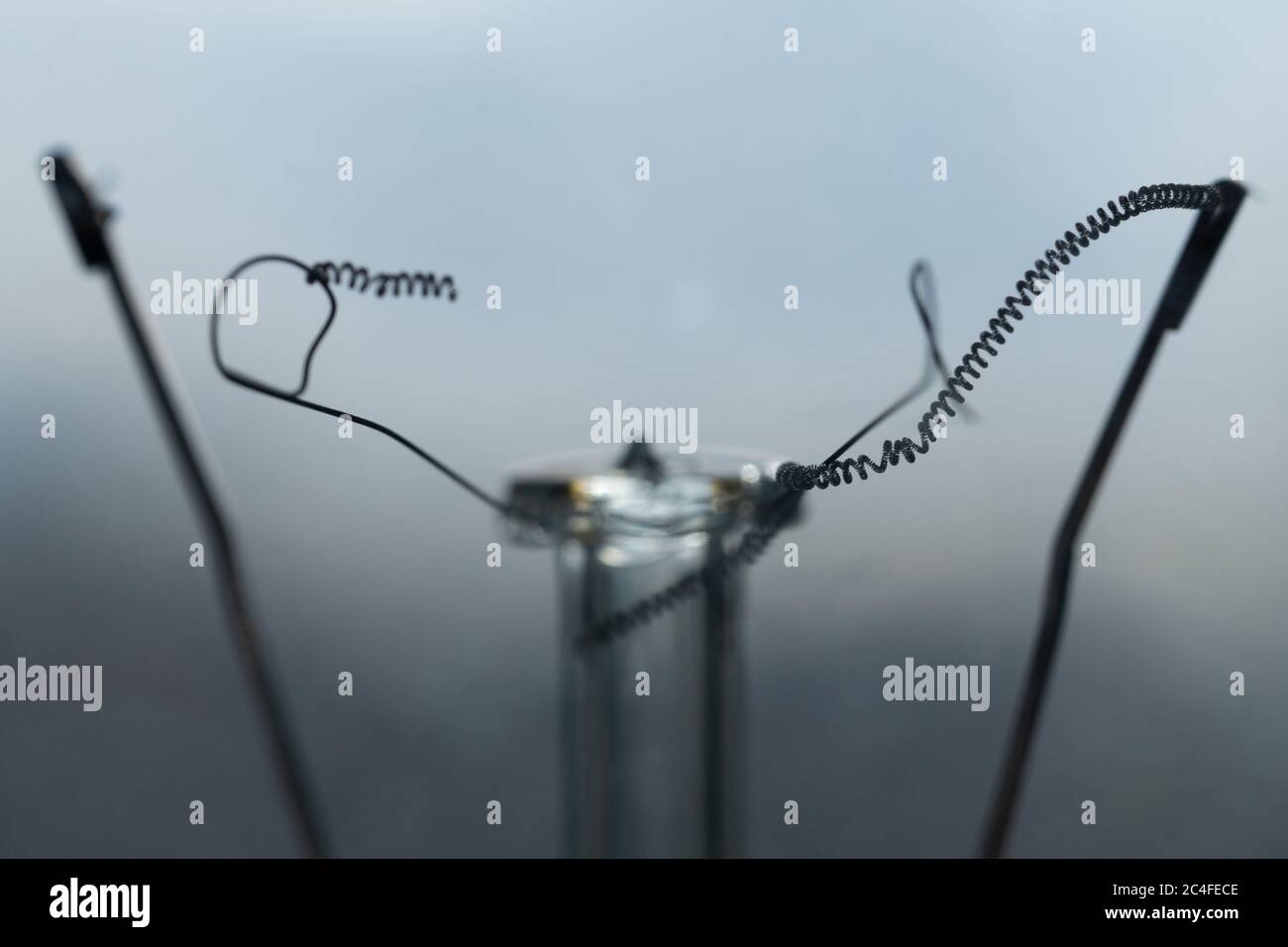 Foto macro di un filamento rotto di una lampadina a incandescenza bruciata. Lampadina della luce elettrica non funzionante. Lampadina bruciata. Lampada accesa. Foto Stock