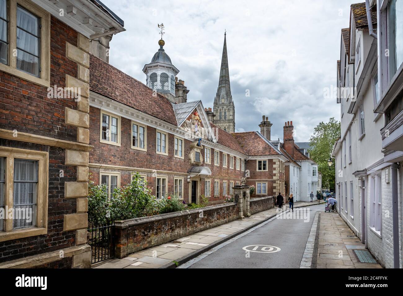La guglia della Cattedrale di Salisbury con le case delle elemosine del XVII secolo in primo piano, prese in High Street, Salisbury, Wiltshire, Regno Unito il 19 giugno 2020 Foto Stock