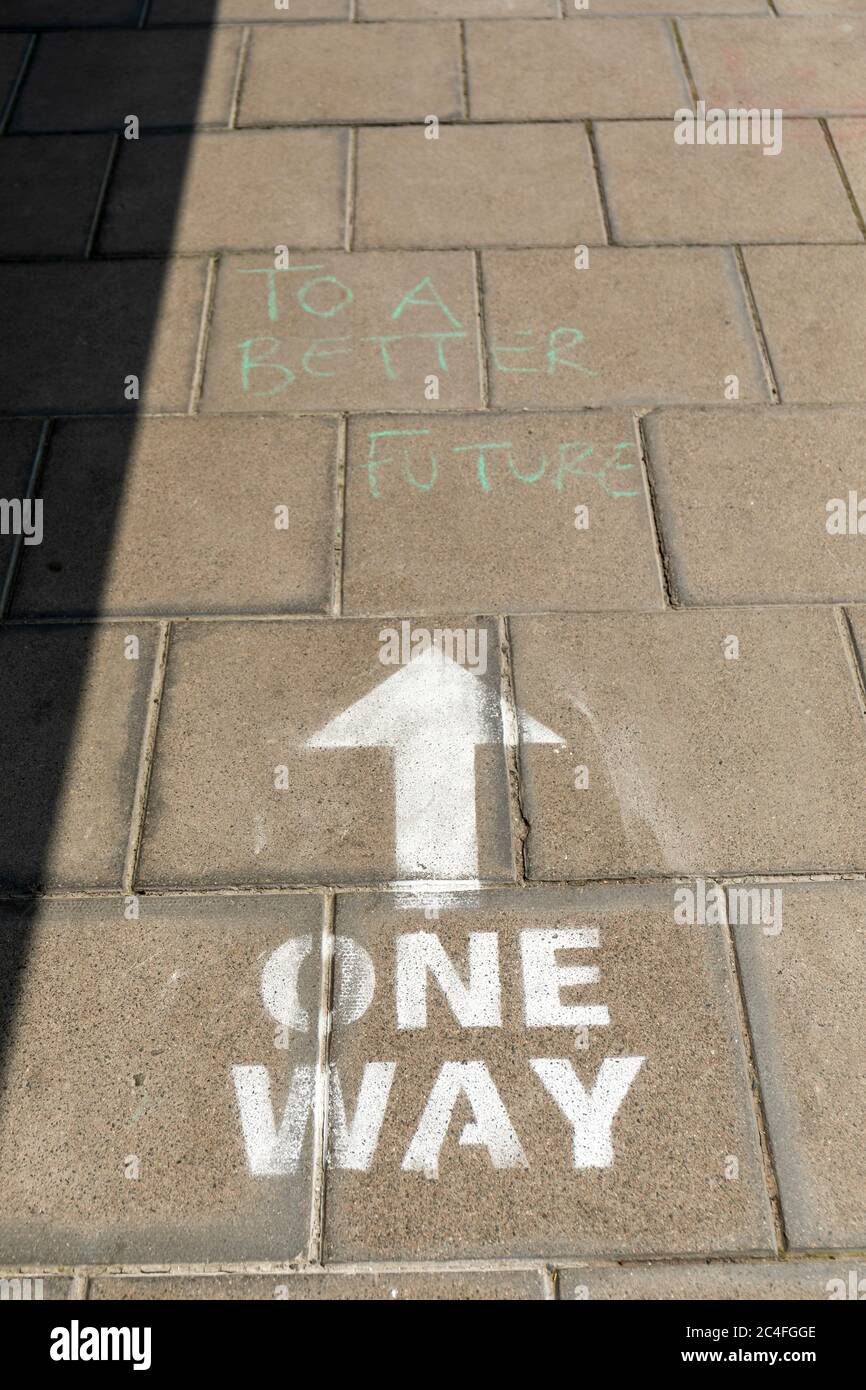 One Way Covid 19 messaggio di allontanamento sociale su un marciapiede a Bristol. Ad un futuro migliore aggiunto in verde. Clifton Village, Bristol, Inghilterra, Regno Unito Foto Stock