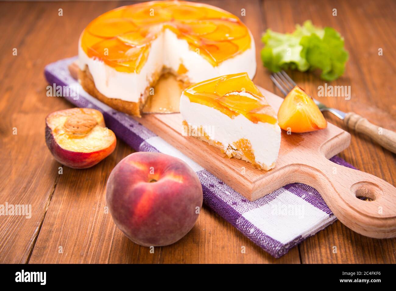 torta di pesche su piatto con pesche fresche e lattuga in studio Foto Stock