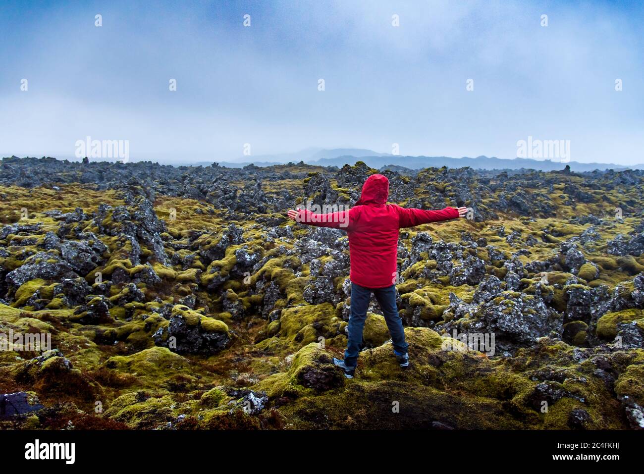 Solo viaggiatore maschile visitando le viste panoramiche del campo di lava in Islanda Foto Stock