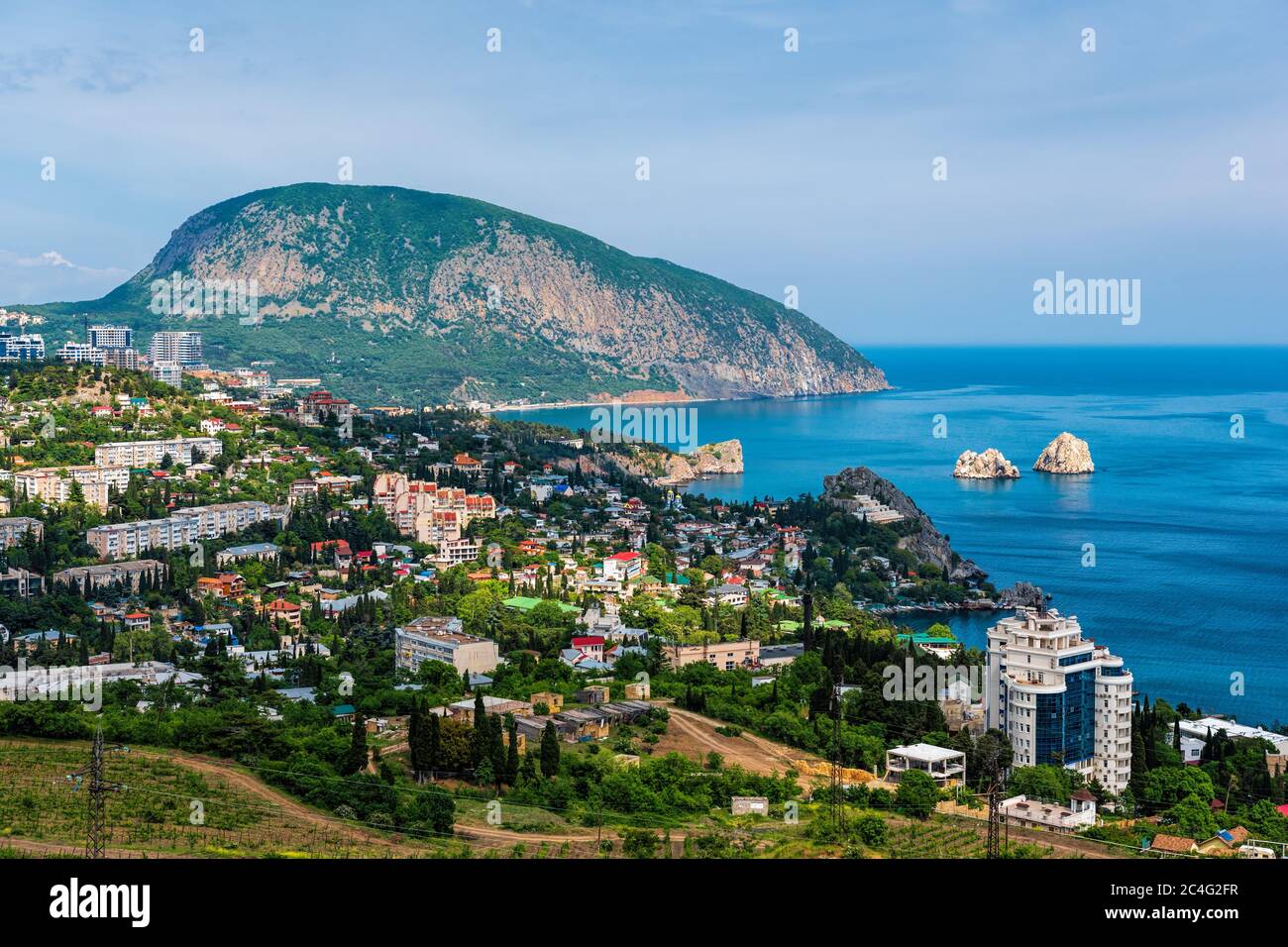 Vista panoramica sulla città Gurzuf e Bear Mountain, Au-Dag, Crimea. Giorno di sole. Il concetto di vita cittadina in unità con la natura. Foto Stock