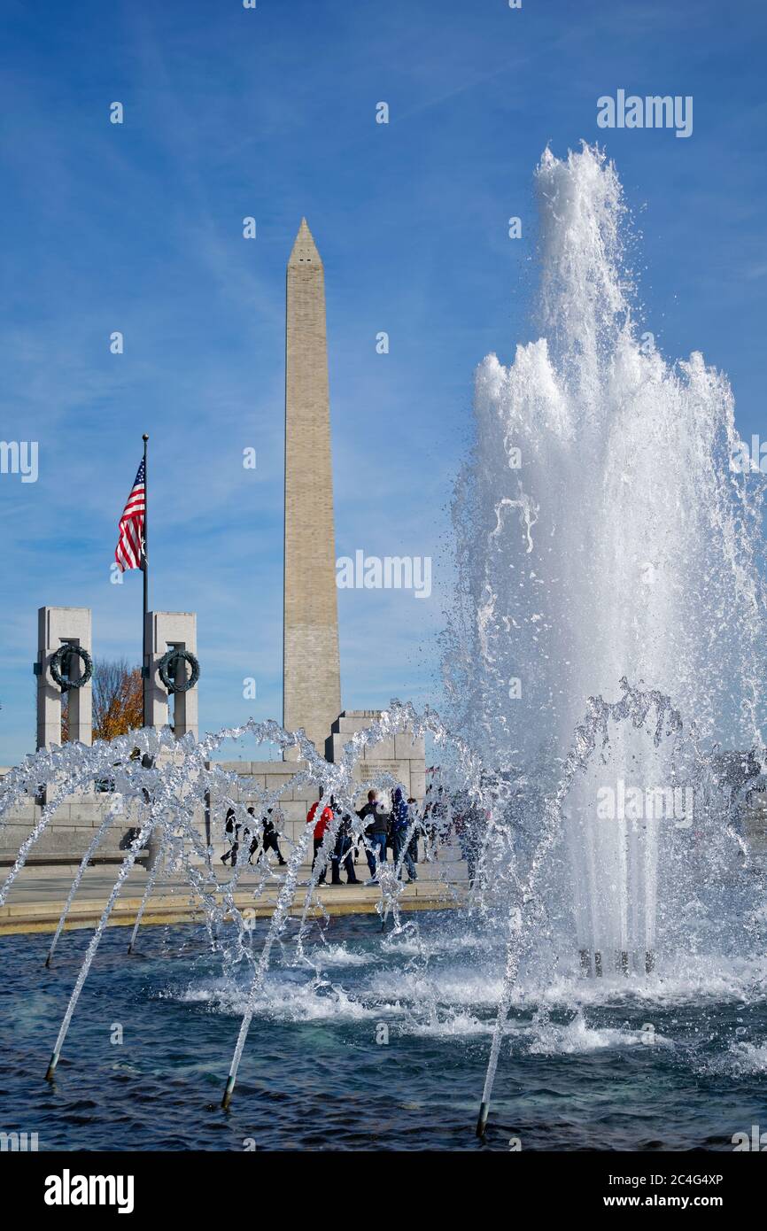 I turisti e il monumento di Washington sono visti dietro la fontana del memoriale della seconda Guerra Mondiale, situata sul National Mall, Washington, DC, USA Foto Stock