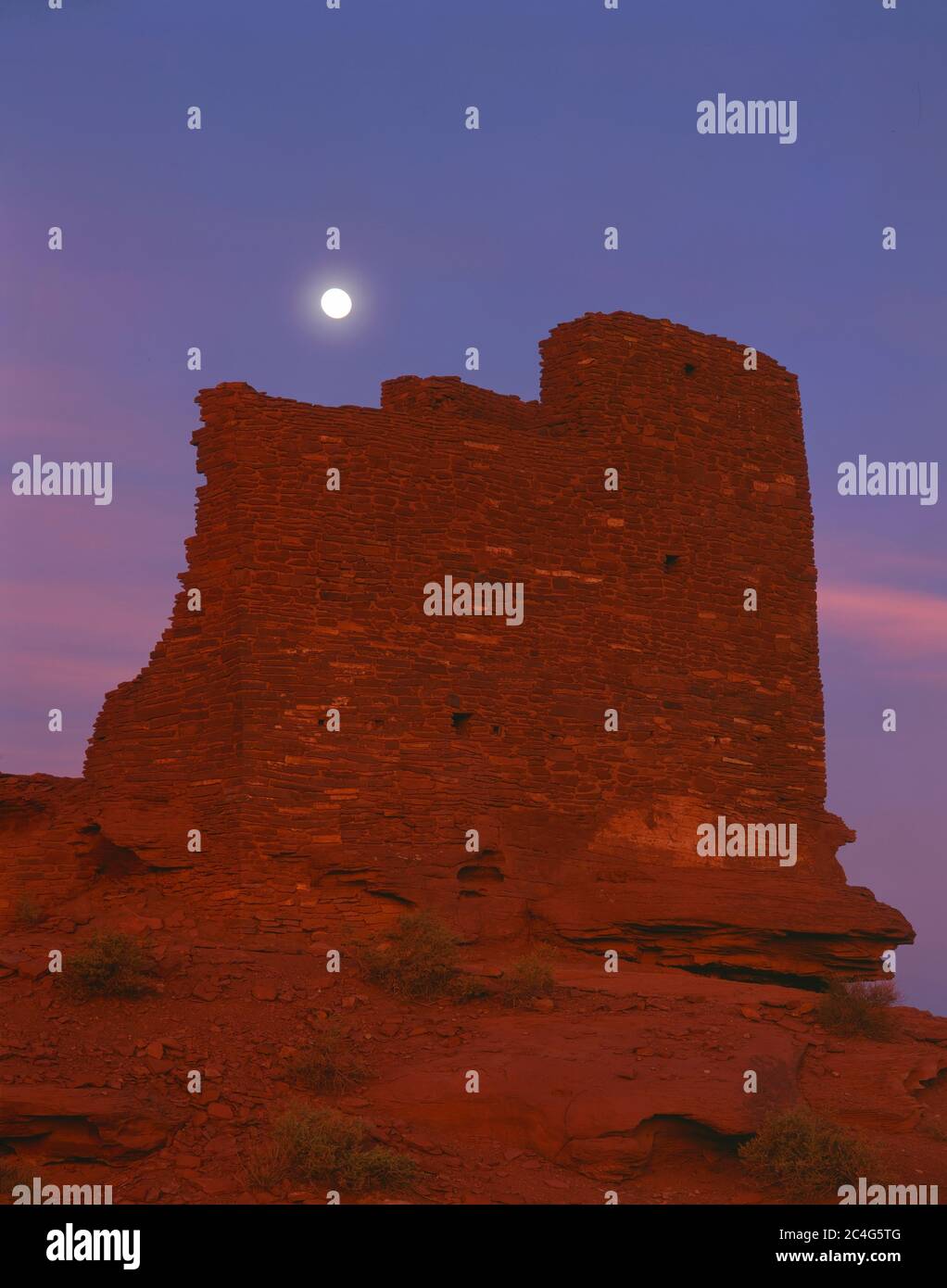 Wupatki National Monument AZ / AGO Luna piena all'alba sopra la rovina del Sinaguan Wukoki anche conosciuto come 'la Grande Casa' Foto Stock