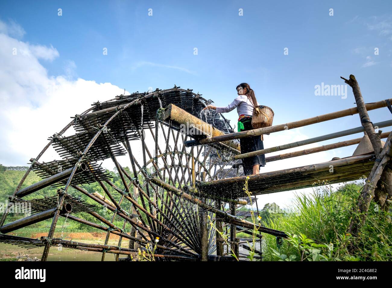 Comune di Kha Cuu, distretto di Tan Son, provincia di Phu Tho, Vietnam - 28 maggio 2020: Donna di minoranza etnica essere ruota laterale di bambù Foto Stock