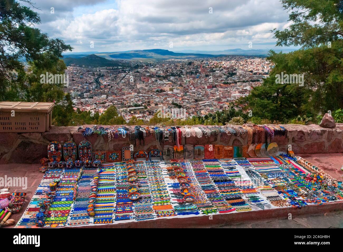 Zacatecas, Messico - 25 ottobre 2006: Colorata arte popolare fatta dagli indigeni Huichol indiani, in cima Cerro De la Buffa montagna, con una vista della città b Foto Stock